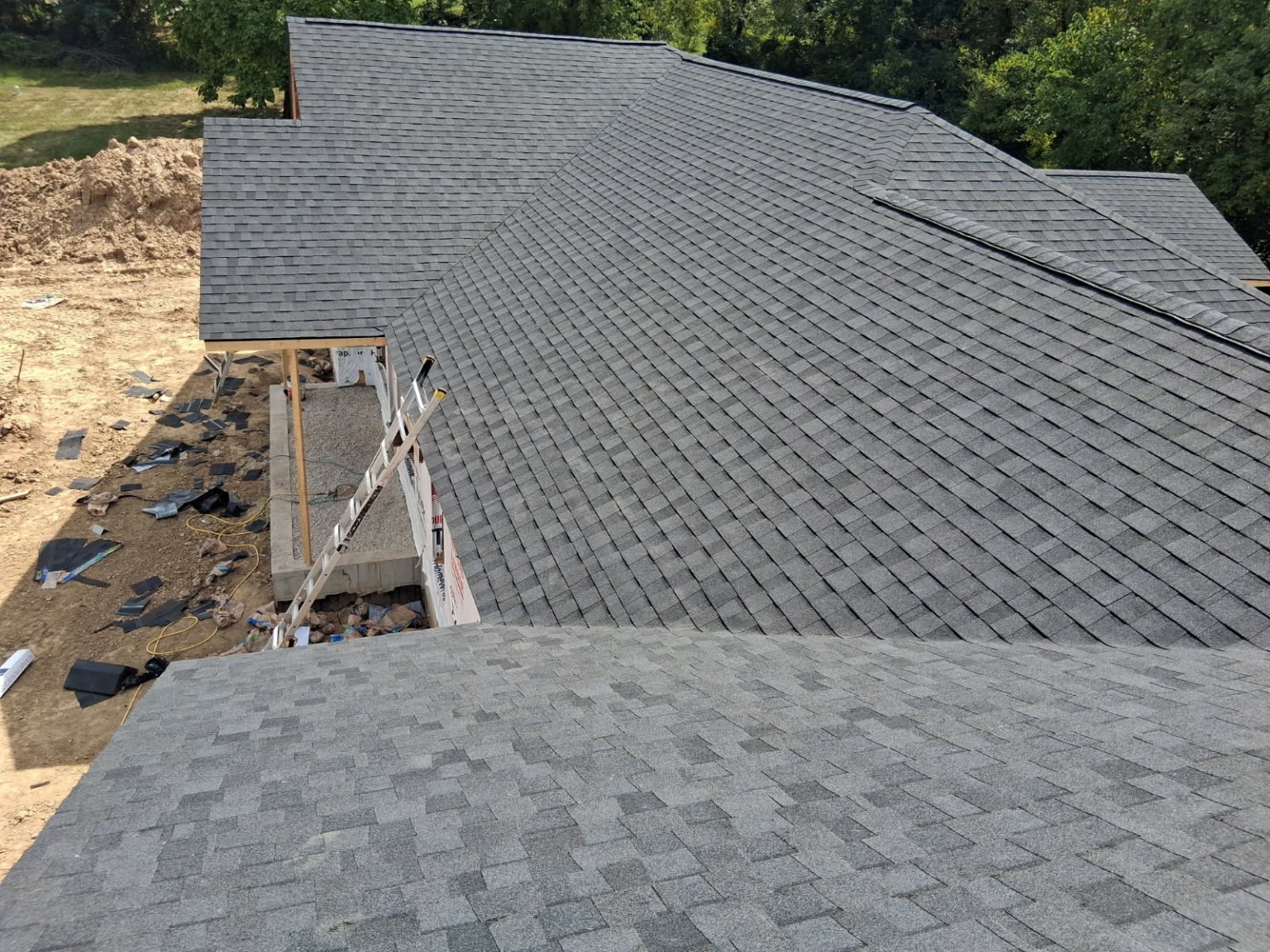 Gray architectural shingles across a residential roof during installation